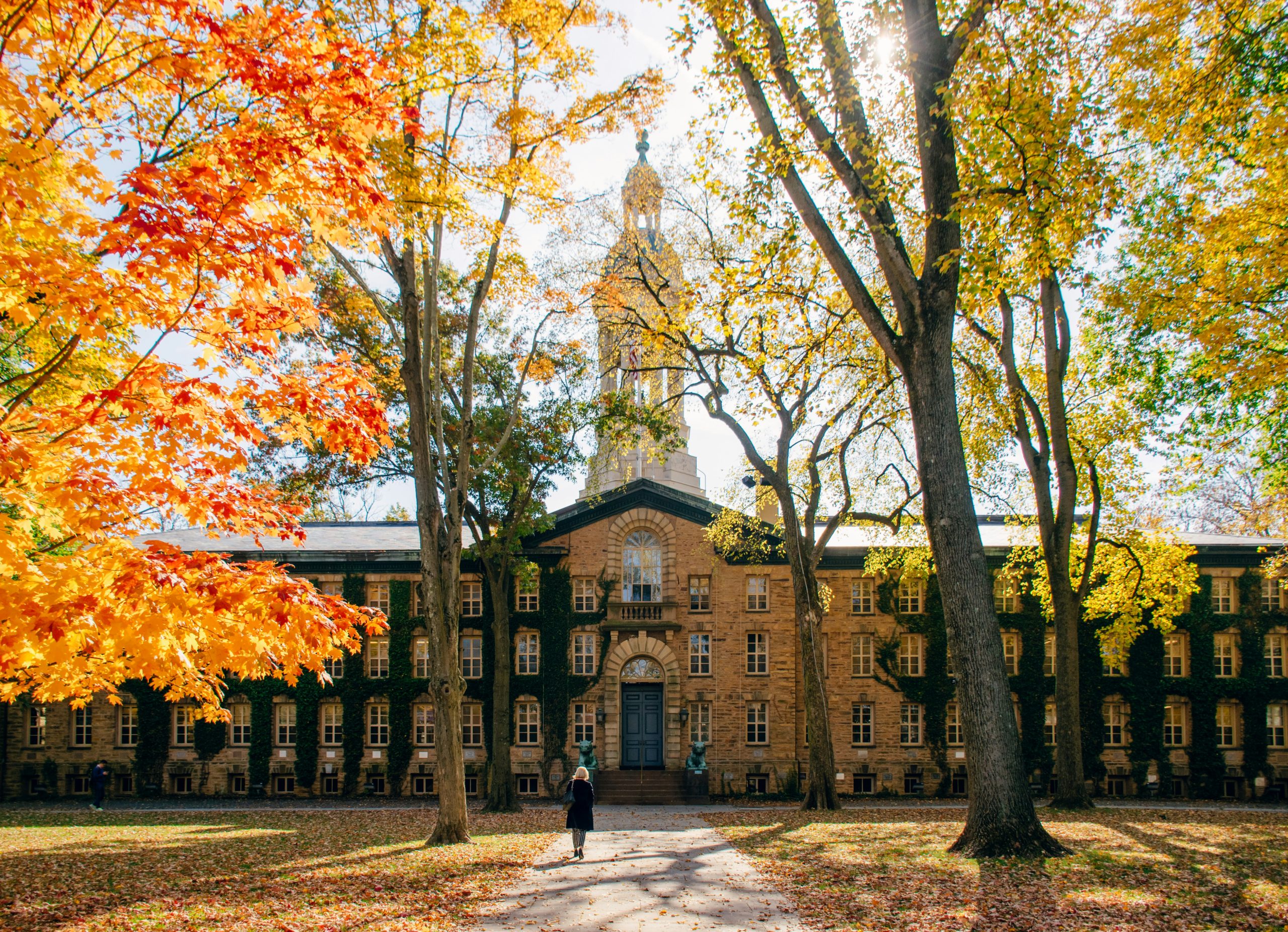 person walking on a pathway in front of brown concrete building during daytime, princeton, day trips from nyc
