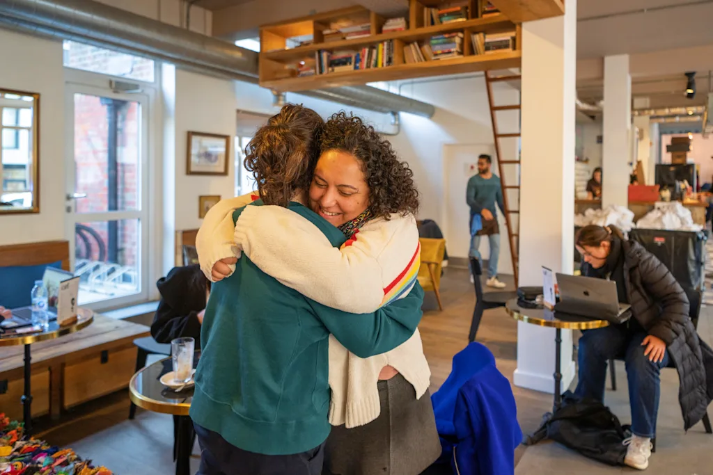 women hugging in a hostel common room