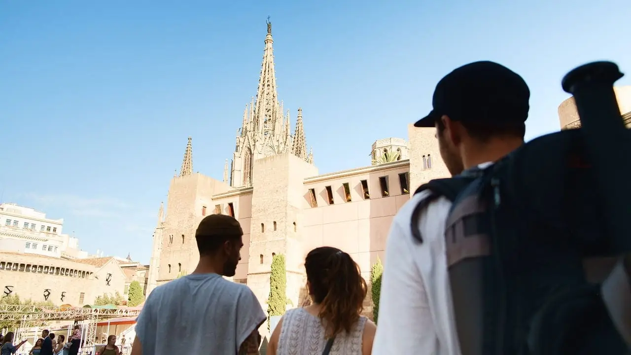 Travellers with backpacks looking up at a cathedral